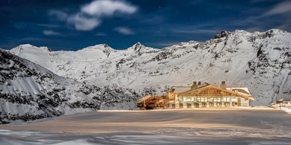 Skiregion - Skiverleih bei Talstation - Hohe Mut Alm.
Hochgenuss am schönsten Bergrücken Tirols

Der Aussichtsberg Hohe Mut am südlichen Rand des Skigebiets serviert einen Rundumblick auf 21 Dreitausender und Gletscher. Doch damit nicht genug: Das 2.670 m hoch gelegene Bergrestaurant Hohe Mut Alm garniert die Aussicht mit kulinarischen Kreationen auf höchstem Niveau. Auf der großen Sonnenterrasse verschmelzen alle Sinneseindrücke zu einem einzigen Wort: Wow! Highlight jeden Mittwoch ab 18.30 Uhr ist der beschwingte Hüttenabend.

Glanzstück der Berggastronomie.
Neben der Bergstation der Hohe Mut Bahn II heißt die gemütliche Hohe Mut Alm hungrige Wintersportler willkommen. Viel Holz im traditionellen alpinen Stil erfüllt die Stuben mit warmer Gastlichkeit. Große Panorama-Fenster öffnen den Raum nach draußen, wo die Terrasse als chillige Lounge und sonniger Logenplatz zum Naturschauspiel dient. Passend zu diesem ganz und gar nicht alltäglichen Ambiente schmeckt auch die Kochkunst nach Mehr: Qualität, Hingabe und Raffinesse.

Jeden Mittwoch ab Mitte Dezember klingt der Skitag in Obergurgl-Hochgurgl am besten beim Hüttenabend in der Hohe Mut Alm aus. Auffahrt (kostenlos) ist um 18.30 Uhr – mit der topmodernen 8er-Kabinenbahn gelangt man komfortabel in 9 Minuten vom Ortszentrum Obergurgl zur Bergstation. Zum Empfang wärmt ein Punsch aus dem Kupferkessel, bevor das aufmerksame Service-Team ein Gourmetfondue mit Filets, Garnelen und vielen anderen Delikatessen auftischt. Livemusik krönt die Hüttengaudi in den Stuben, bevor es zurück ins Tal geht (Abfahrt ab 22.30 Uhr).

„Ja, ich will“: Immer mehr Paare sprechen die magischen drei Worte mitten im Obergurgler Winter aus. Die 2.670 m hoch gelegene Hohe Mut Alm hat sich als beliebte Hochzeitslocation etabliert und erfüllt alle Wünsche an den schönsten Tag des Lebens. So schwebt das Brautpaar in einer festlich geschmückten Hochzeitsgondel hinauf zur standesamtlichen Trauung am Berg, wo bis zu 230 Gäste auf der Sonnenterrasse und in exklusiven Stuben Platz finden. Auch um das Festmenü, Dekoration, Musik und Fotografen kümmern sich die Gastgeber gerne. Nur noch Ja sagen müssen Sie selbst. - Skigebiet Gurgl